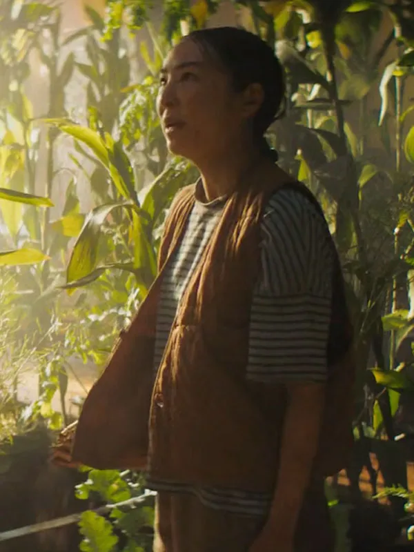 Greta Lee side profile in greenhouse wearing The Last House Quilted Vest