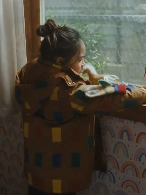 Riley Chung wearing The Last House Brown Color Block Jacket by window. The Last House Movie Riley Chung Brown Jacket