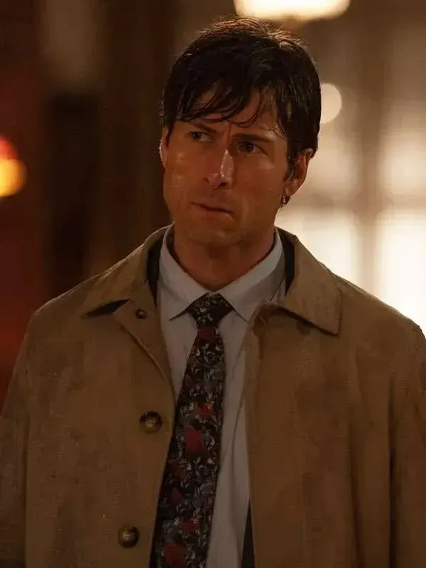 Front view of Glen Powell wearing the beige cotton coat with a patterned tie in Becket. Glen Powell Beige Cotton Coat