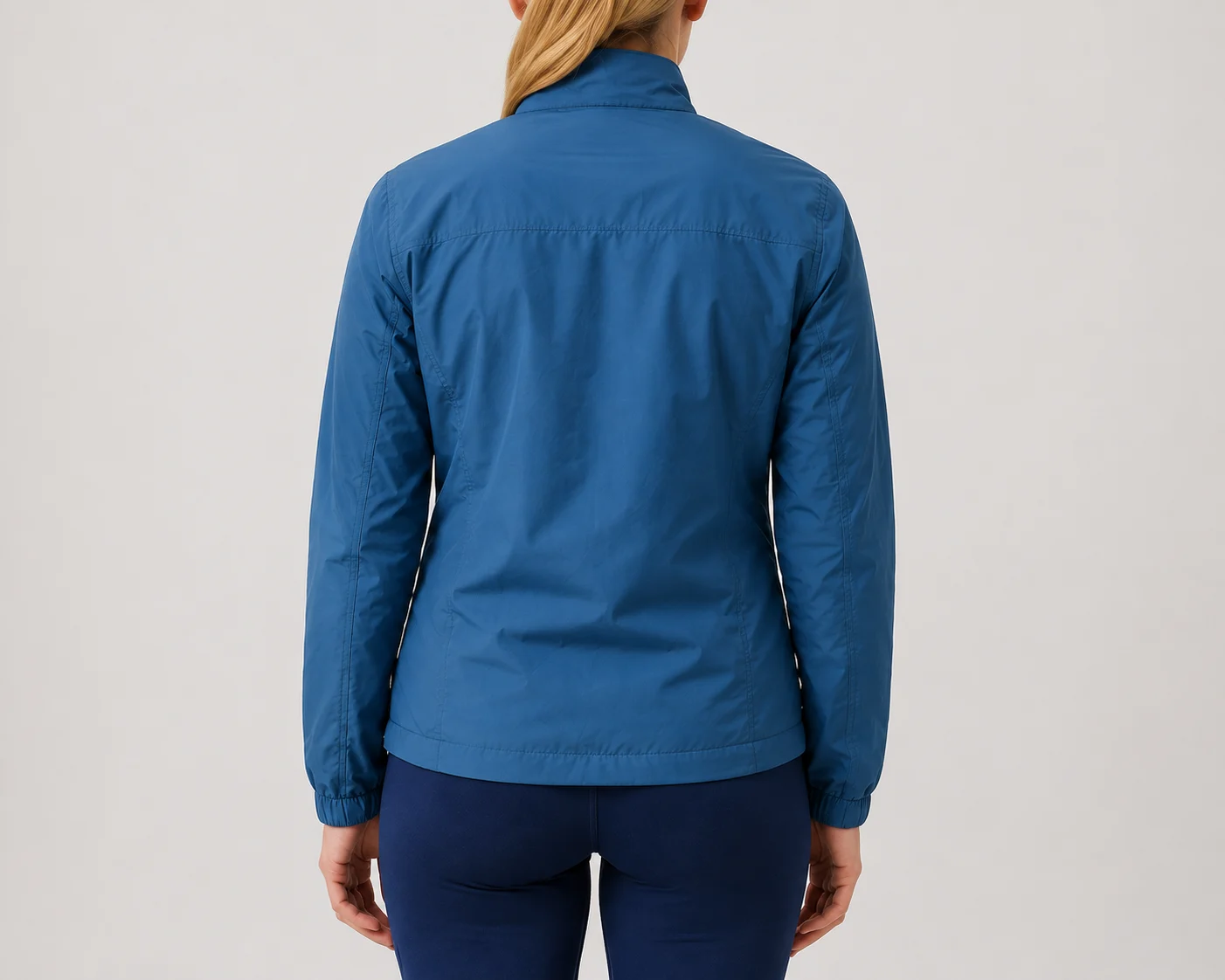Back view of women's blue windbreaker showing shoulder stitching