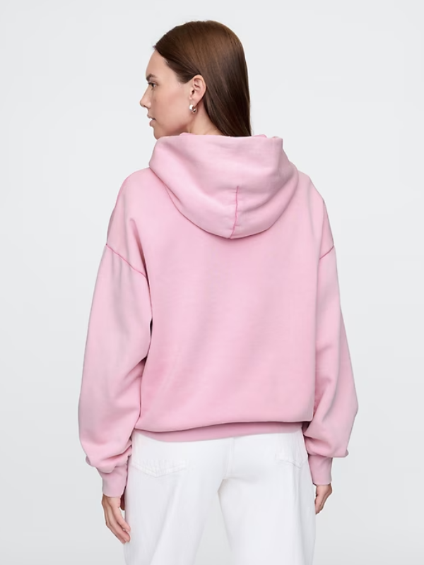 Back view of model wearing the Wicked Pink Logo Hoodie paired with white pants