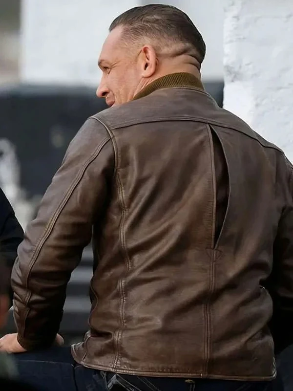 Back view of Tom Hardy wearing the brown distressed leather jacket showcasing action-back shoulder pleats, ribbed collar, and structured back yoke