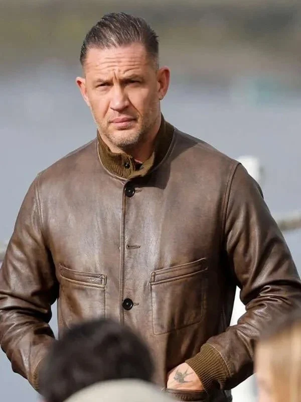 Front view of Tom Hardy wearing the brown distressed leather jacket with button closures, chest patch pockets, and ribbed stand-up collar. Mobland Tom Hardy Brown Leather Jacket