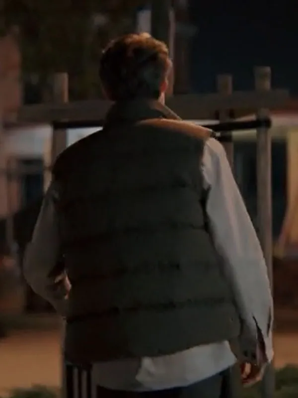 Back view of Pavel Kuzmin wearing the olive green puffer vest featuring horizontal quilted baffles