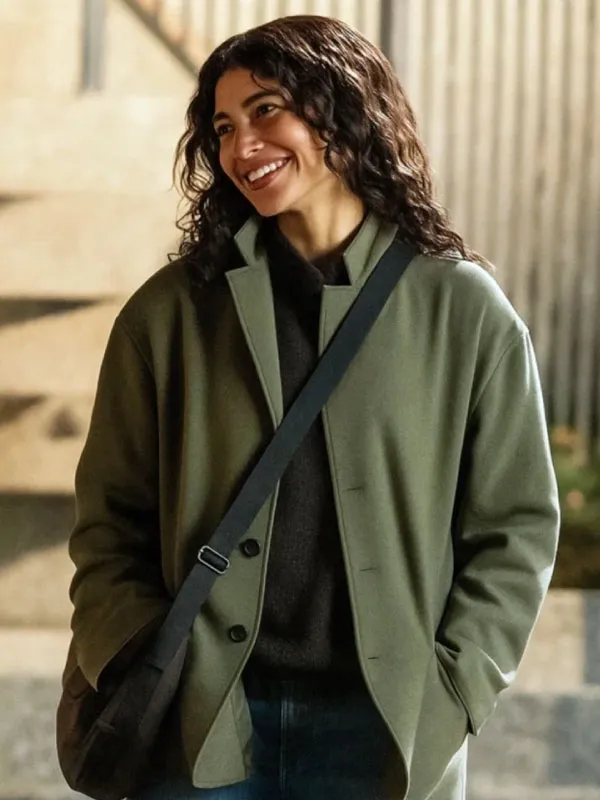 Front view of the olive green cotton jacket featuring a button-up front, lapel collar, and side pockets worn with a dark sweater. The Drama Emma Harwood Green Cotton Jacket